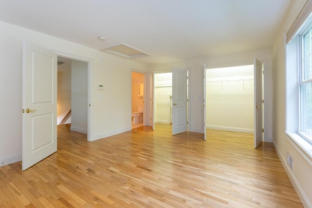14 Chandler Ln, Amherst, NH 03031 - unfurnished bedroom featuring light wood finished floors, a walk in closet, attic access, a closet, and connected bathroom