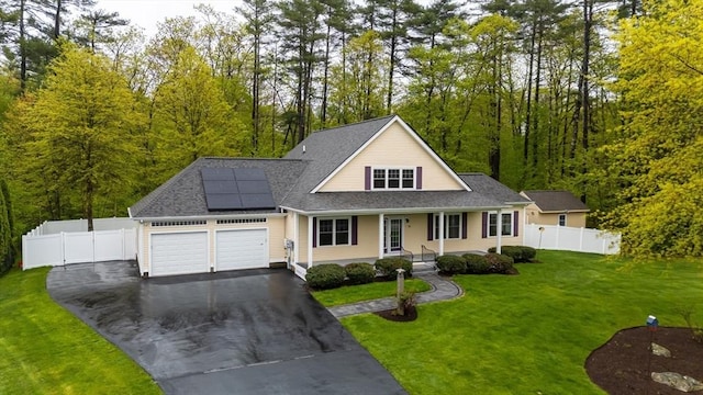 14 Chandler Ln, Amherst, NH 03031 - view of front facade with asphalt driveway, a garage, covered porch, roof mounted solar panels, and a shingled roof