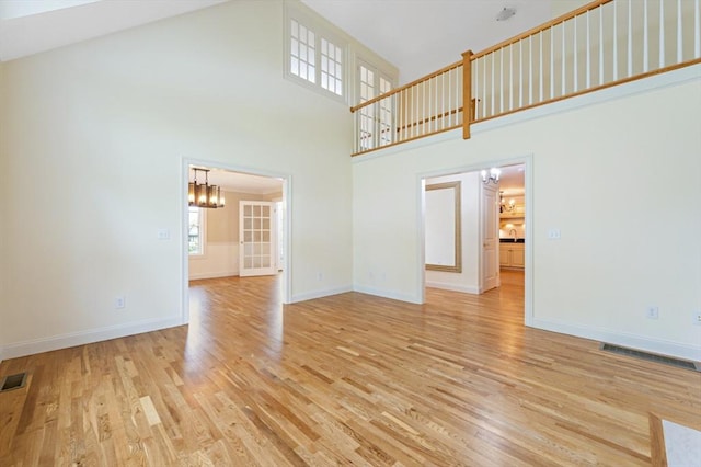 14 Chandler Ln, Amherst, NH 03031 - unfurnished living room featuring a high ceiling, a chandelier, and light wood finished floors