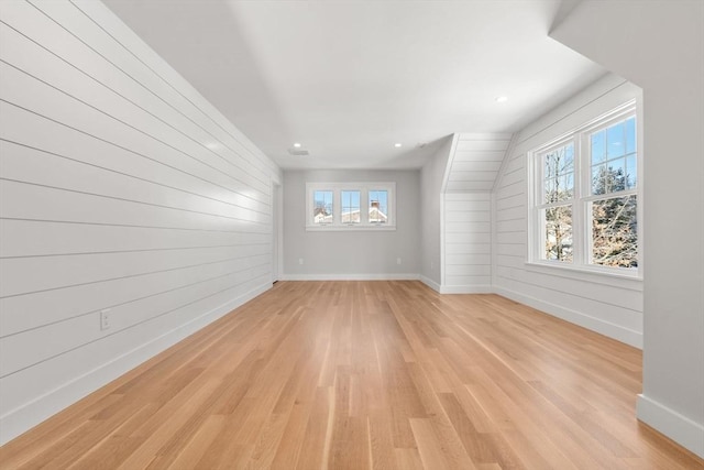 empty room featuring wood walls and light hardwood / wood-style floors