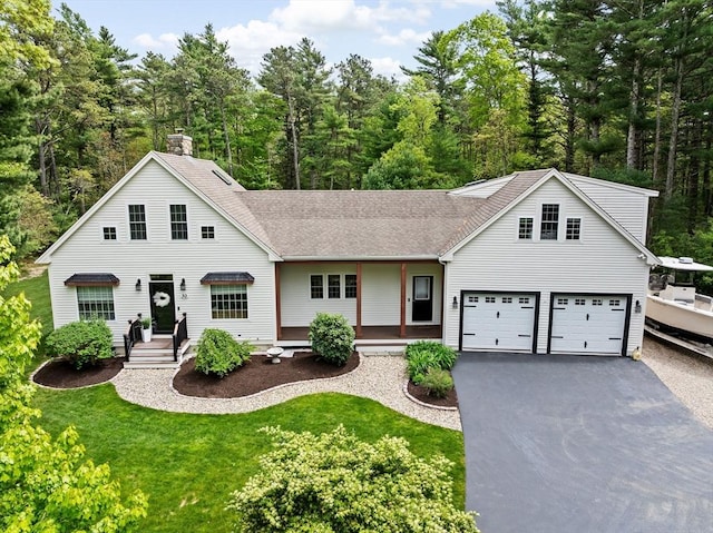 traditional-style home featuring asphalt driveway, a front yard, roof with shingles, and a chimney