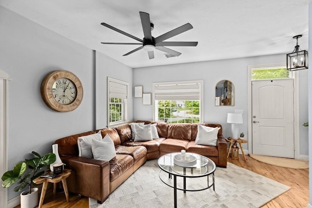 living area featuring wood finished floors, a ceiling fan, and a chandelier