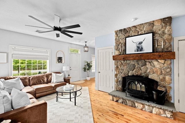 living area featuring light wood-style flooring, ceiling fan, and baseboards