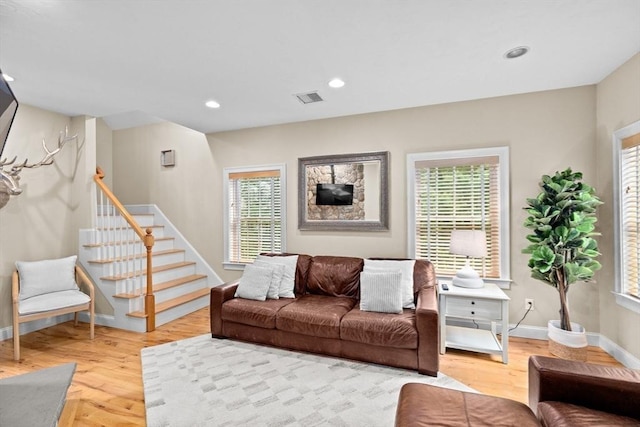 living room with light wood-style floors, stairs, baseboards, and recessed lighting