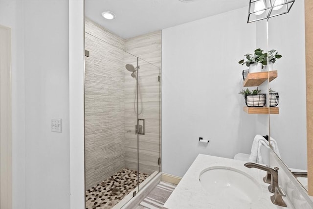 full bath with a stall shower, vanity, and baseboards