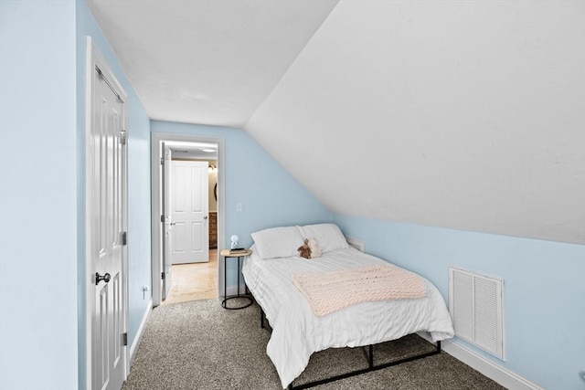 carpeted bedroom with baseboards and lofted ceiling