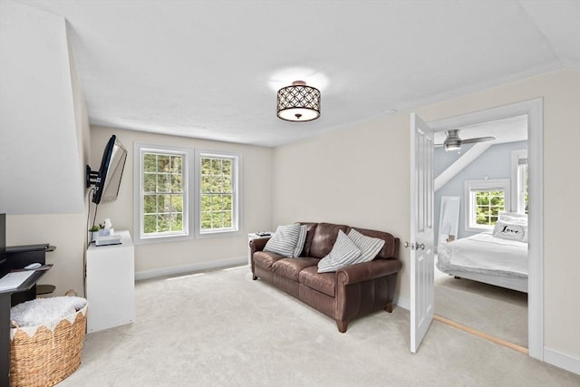 carpeted living room featuring baseboards, lofted ceiling, and a ceiling fan