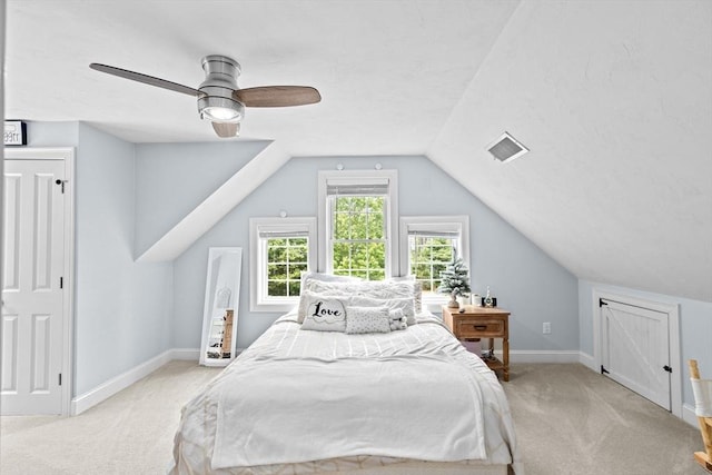 bedroom with light colored carpet, vaulted ceiling, baseboards, and ceiling fan