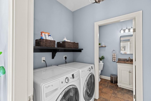 laundry area with washer and clothes dryer, dark stone finish flooring, and baseboards