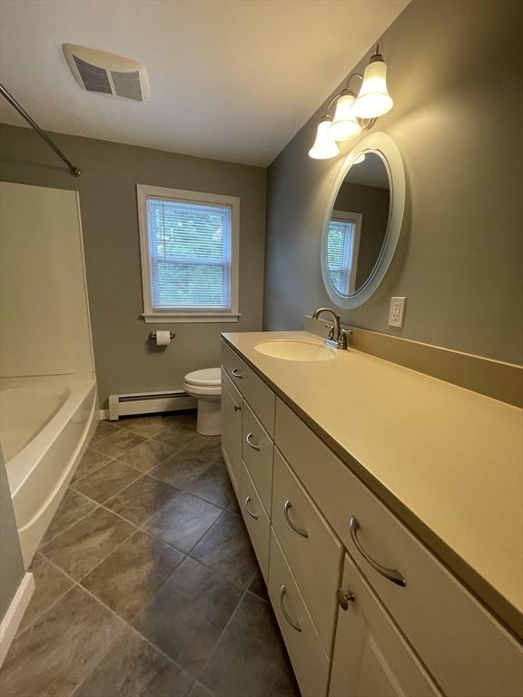full bathroom with baseboard heating, baseboards, vanity, toilet, and tile patterned flooring