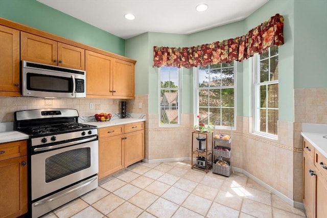 41 Edward Dr Unit 41, Grafton, MA 01536 - kitchen featuring stainless steel appliances, tile walls, wainscoting, light countertops, and light tile patterned floors