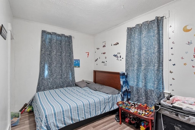 376 Elm St, Fitchburg, MA 01420 - bedroom featuring wood finished floors, a textured ceiling, and ornamental molding