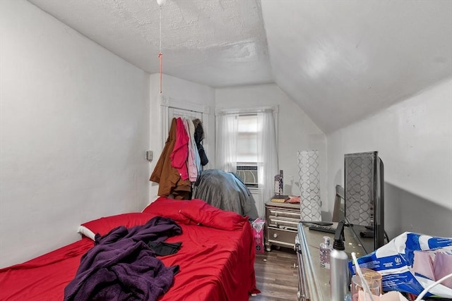376 Elm St, Fitchburg, MA 01420 - bedroom with wood finished floors, vaulted ceiling, a textured ceiling, and cooling unit