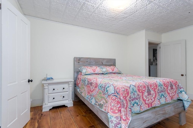 bedroom with wood-type flooring and an ornate ceiling