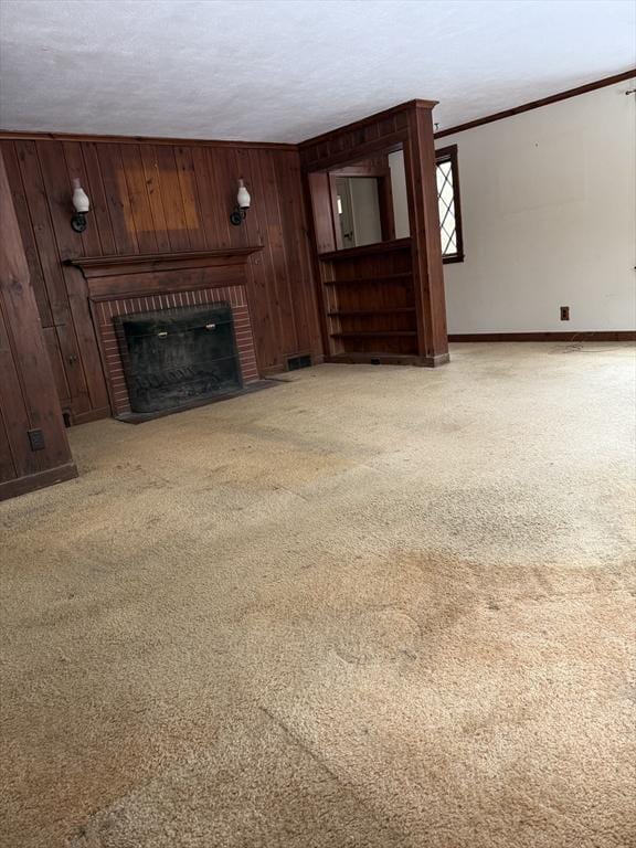 unfurnished living room with light carpet, a brick fireplace, and wooden walls