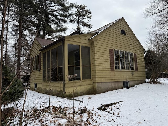 snow covered property with a sunroom