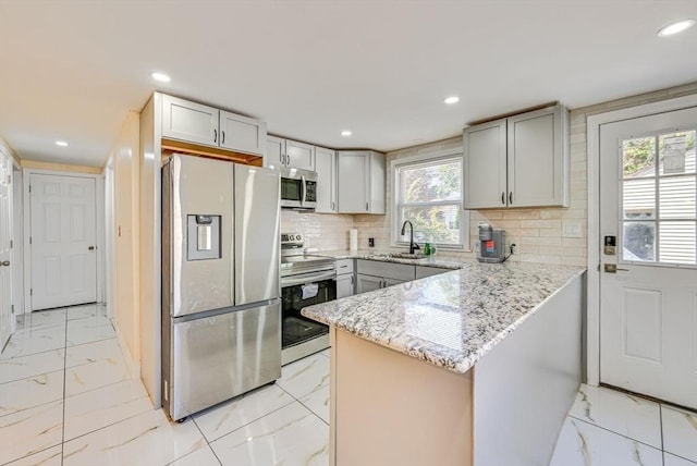 44 Georgetown St, Springfield, MA 01104 - kitchen with appliances with stainless steel finishes, light marble finish floors, a peninsula, tasteful backsplash, and light stone countertops
