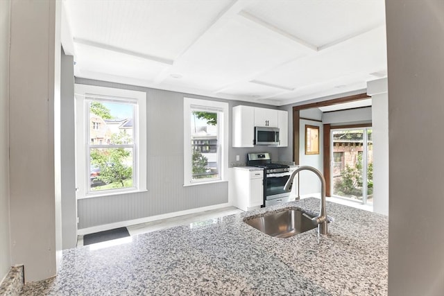 17 Manhattan St, Springfield, MA 01109 - kitchen with stainless steel appliances, a sink, light stone countertops, white cabinets, and baseboards