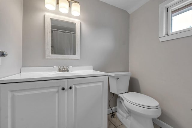 bathroom with vanity, toilet, tile patterned floors, baseboards, and curtained shower