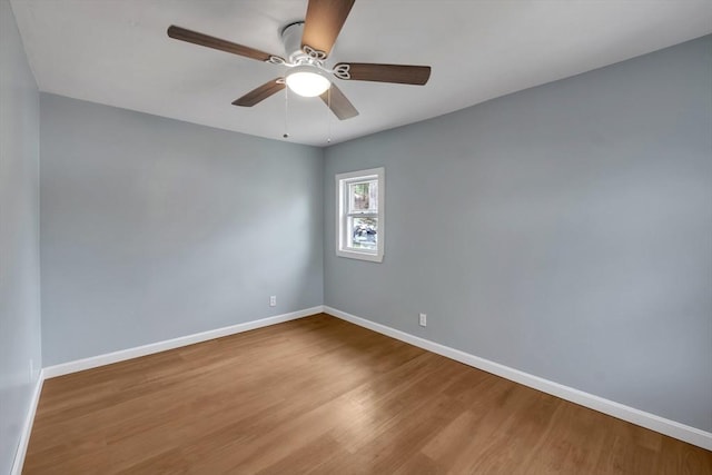 empty room with baseboards, ceiling fan, and wood finished floors