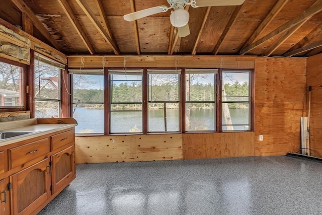 unfurnished sunroom with a sink and a water view
