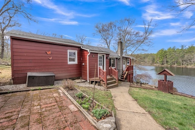 exterior space featuring a water view and a chimney