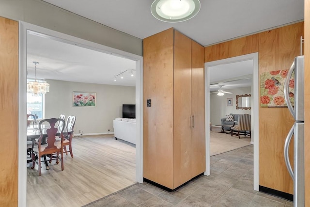 kitchen featuring stainless steel refrigerator, rail lighting, a chandelier, and pendant lighting