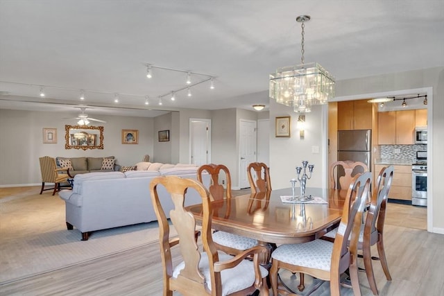 dining room with ceiling fan and light hardwood / wood-style flooring