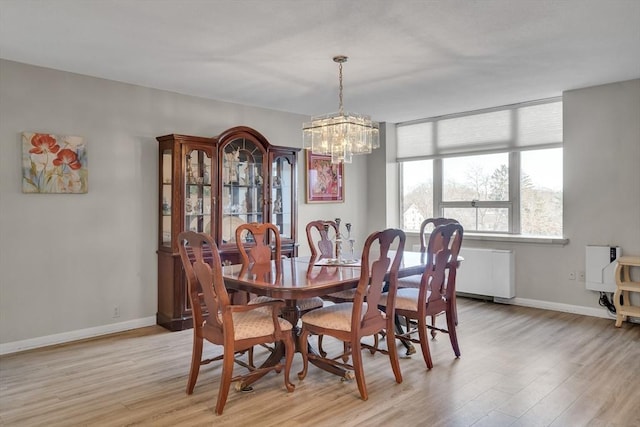 dining space with an inviting chandelier and light hardwood / wood-style floors