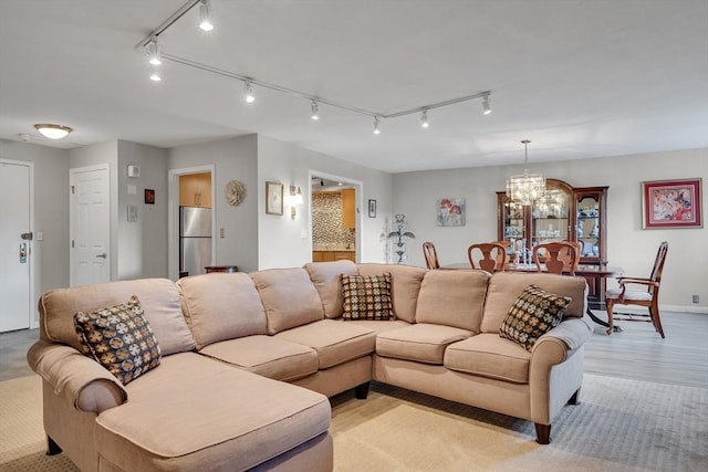 living room with an inviting chandelier and light hardwood / wood-style floors