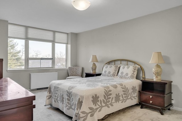 carpeted bedroom with radiator heating unit and multiple windows