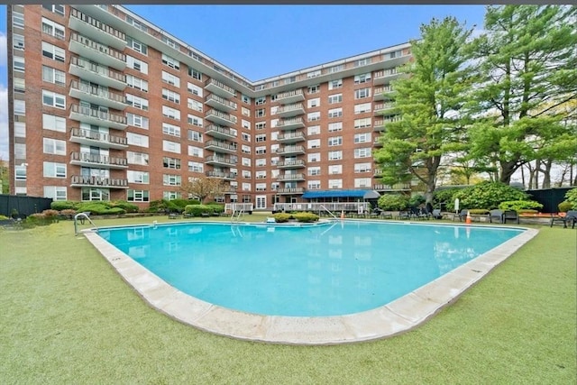 view of pool with a lawn