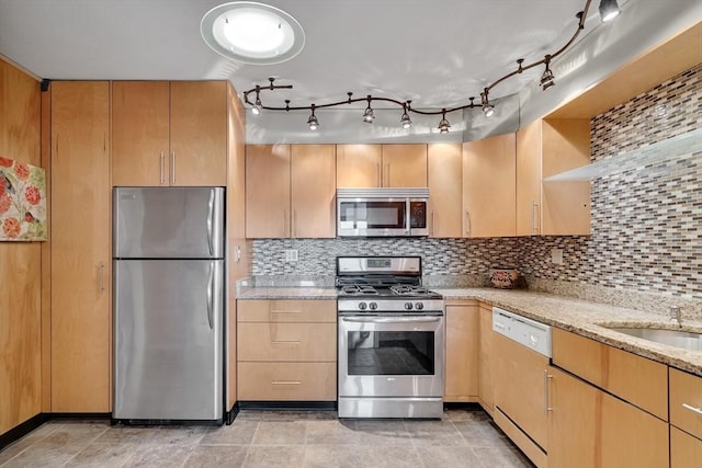 kitchen with light tile patterned floors, appliances with stainless steel finishes, light stone counters, decorative backsplash, and light brown cabinets