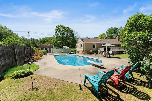 1 Redgate Ln, Holden, MA 01520 - view of swimming pool featuring a diving board, a patio area, a fenced backyard, and an outdoor structure