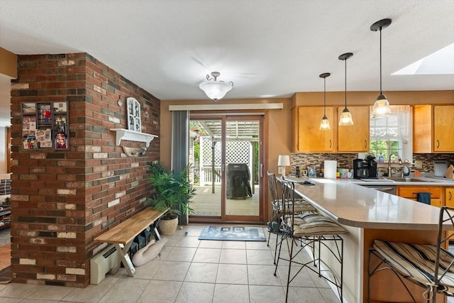 1 Redgate Ln, Holden, MA 01520 - kitchen with plenty of natural light, a breakfast bar, a peninsula, and decorative backsplash