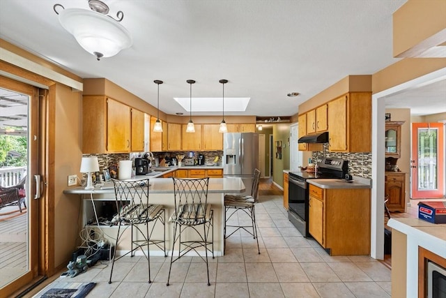 1 Redgate Ln, Holden, MA 01520 - kitchen with appliances with stainless steel finishes, under cabinet range hood, a peninsula, backsplash, and light tile patterned floors