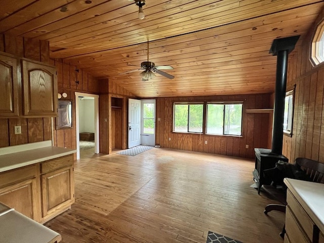 11 Summit Ave, Lakeville, MA 02347 - unfurnished living room with a wood stove, wooden walls, wood ceiling, a ceiling fan, and wood finished floors