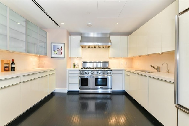 776 Boylston Unit E9C, Boston, MA 02199 - kitchen with appliances with stainless steel finishes, wall chimney exhaust hood, light countertops, dark wood-style flooring, and recessed lighting