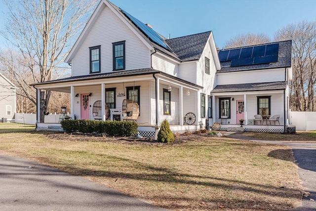 view of front facade with solar panels, a porch, and a front lawn