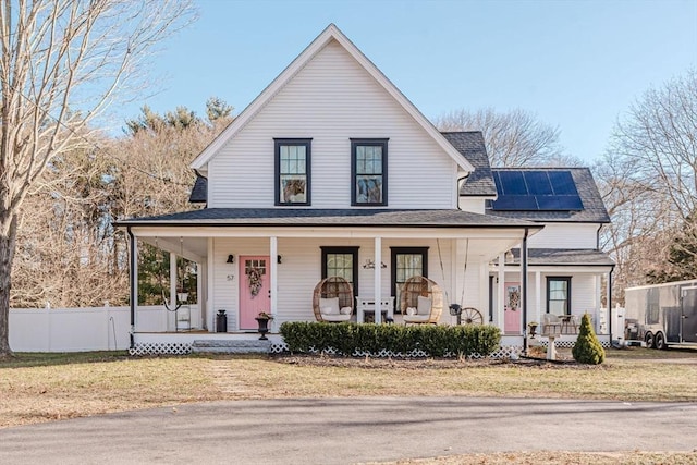 view of front of house featuring a front lawn, covered porch, and solar panels