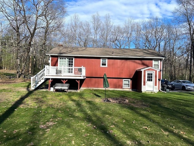 back of property with a lawn and a deck