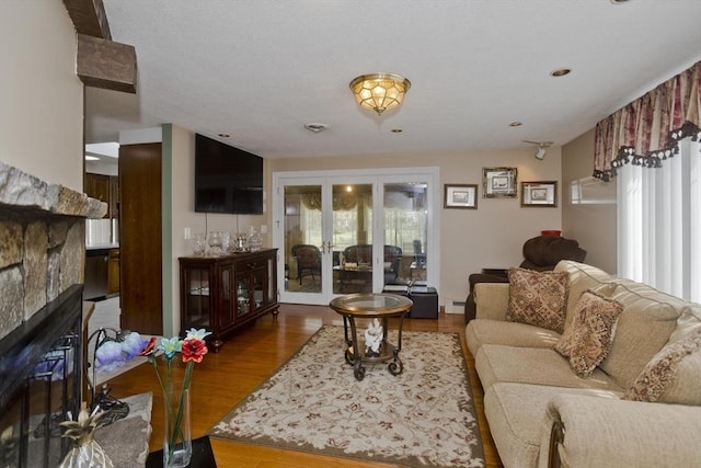 90 Westwood Ave, East Longmeadow, MA 01028 - living area with french doors, a baseboard radiator, a glass covered fireplace, and wood finished floors