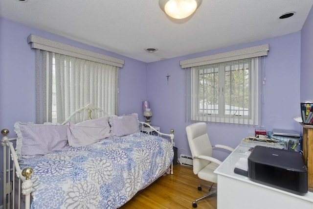 90 Westwood Ave, East Longmeadow, MA 01028 - bedroom with a baseboard heating unit and wood finished floors