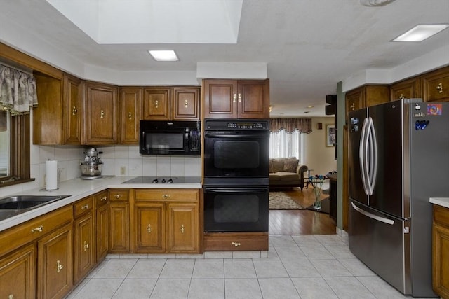 90 Westwood Ave, East Longmeadow, MA 01028 - kitchen featuring light countertops, brown cabinets, and black appliances