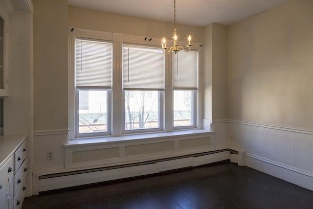 unfurnished dining area with a chandelier, dark hardwood / wood-style flooring, and a baseboard heating unit