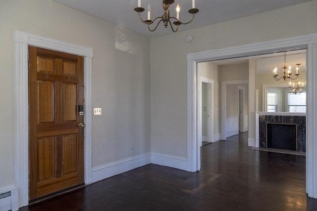 interior space featuring a premium fireplace, a chandelier, dark hardwood / wood-style flooring, and a baseboard radiator