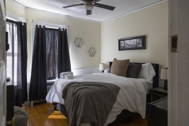 bedroom featuring hardwood / wood-style flooring, crown molding, and ceiling fan