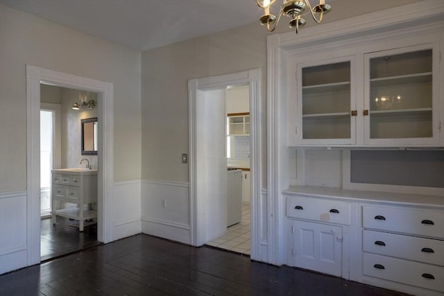 interior space with connected bathroom, dark hardwood / wood-style floors, and an inviting chandelier