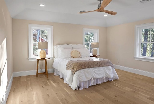 bedroom with ceiling fan, light hardwood / wood-style floors, lofted ceiling, and multiple windows