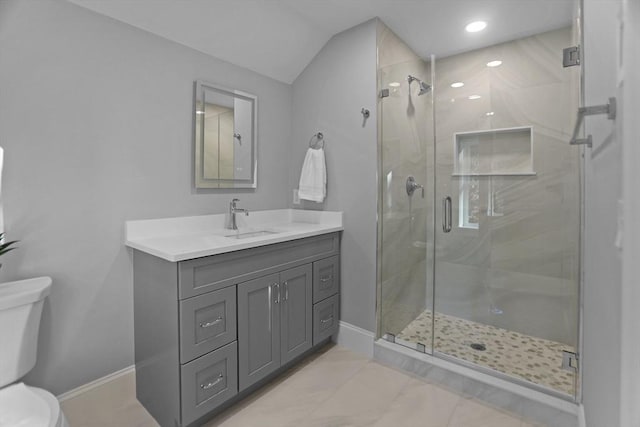 bathroom featuring lofted ceiling, toilet, a shower with shower door, and vanity